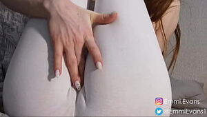 In white spread trousers and socks, she displays her legs and tits
